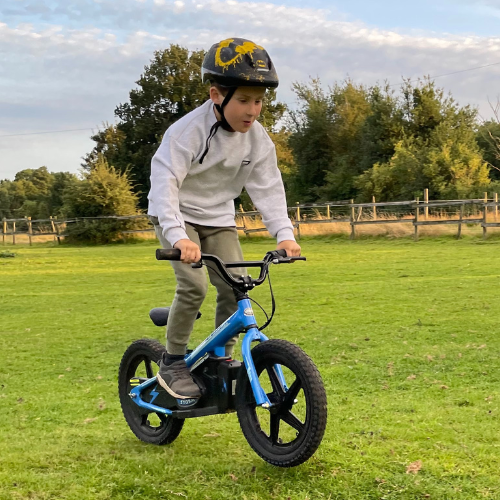  Young boy riding a blue Storm 16" kids electric balance bike